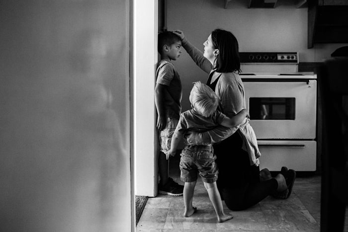 photo-of-mom-measuring-the-height-of-her-son-on-the-wall-by-lacey-monroe